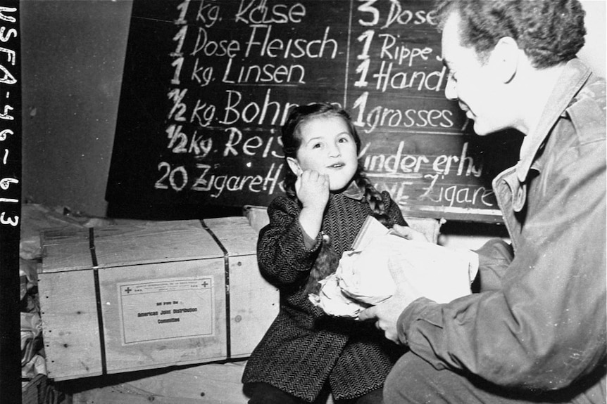 A US army soldier gives food to a Jewish child in Vienna at the end of WWII.
