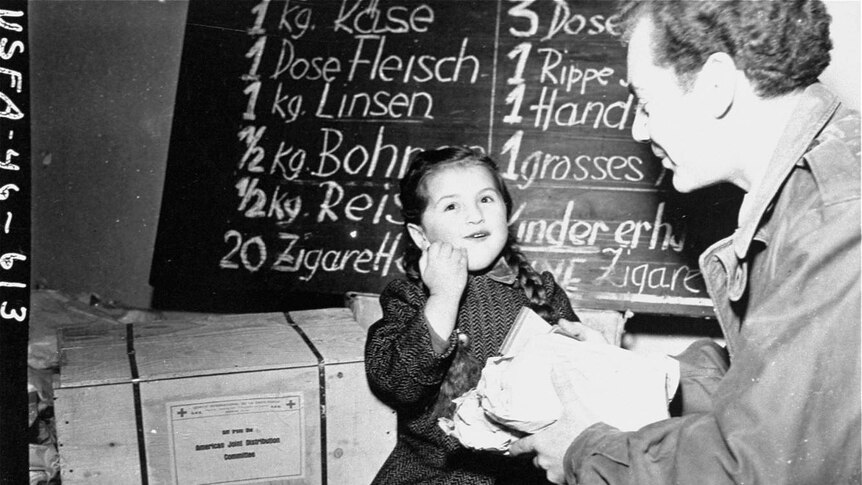 A US army soldier gives food to a Jewish child in Vienna at the end of WWII.