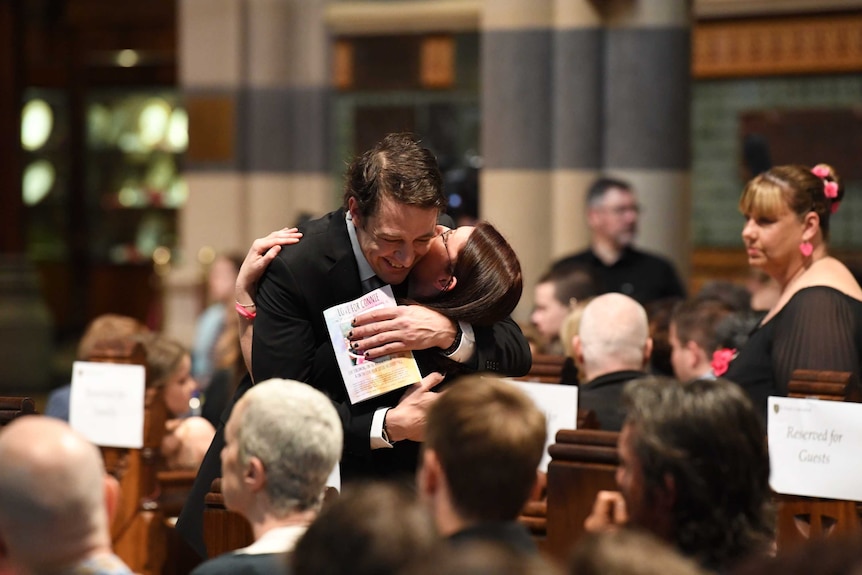 Samuel Johnson hugs a supporter at a memorial service at St Paul's cathedral.