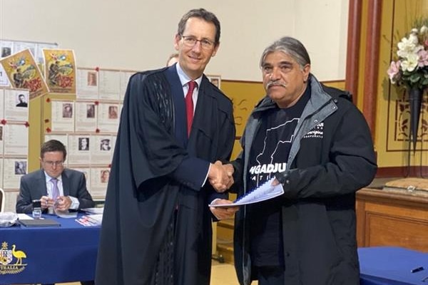 A judge handing an indigenous man documentation 