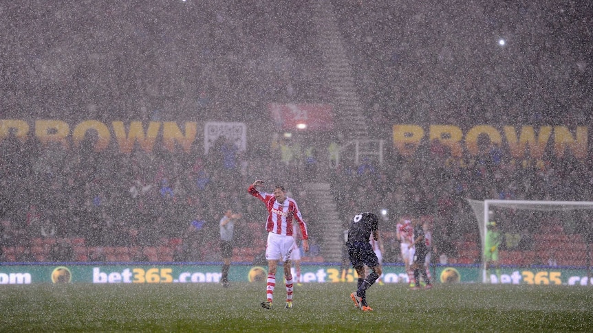 Peter Crouch and Jonny Evans shield themselves from the hail