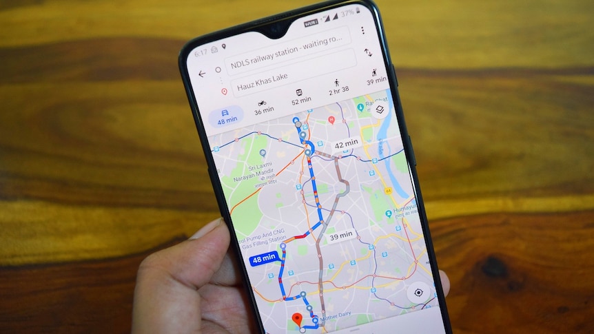 A hand holds a phone looking at a route on the Google Maps app