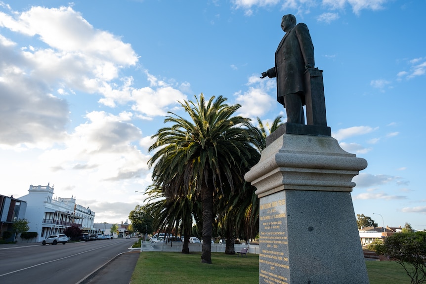A statue of a man on a plinth overlooking the town
