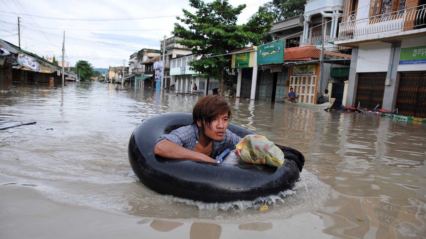 Myanmar resident making his way through flood waters