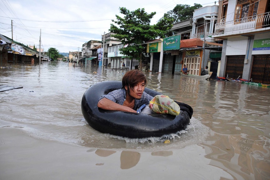 Myanmar resident making his way through flood waters