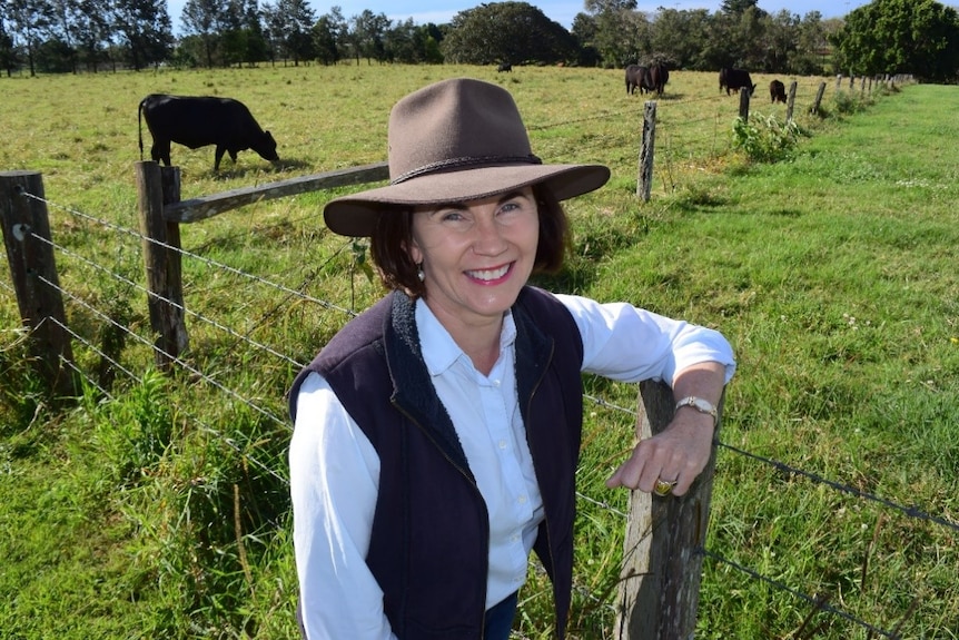 Lorraine Gordon on a farm with black cattle in background.