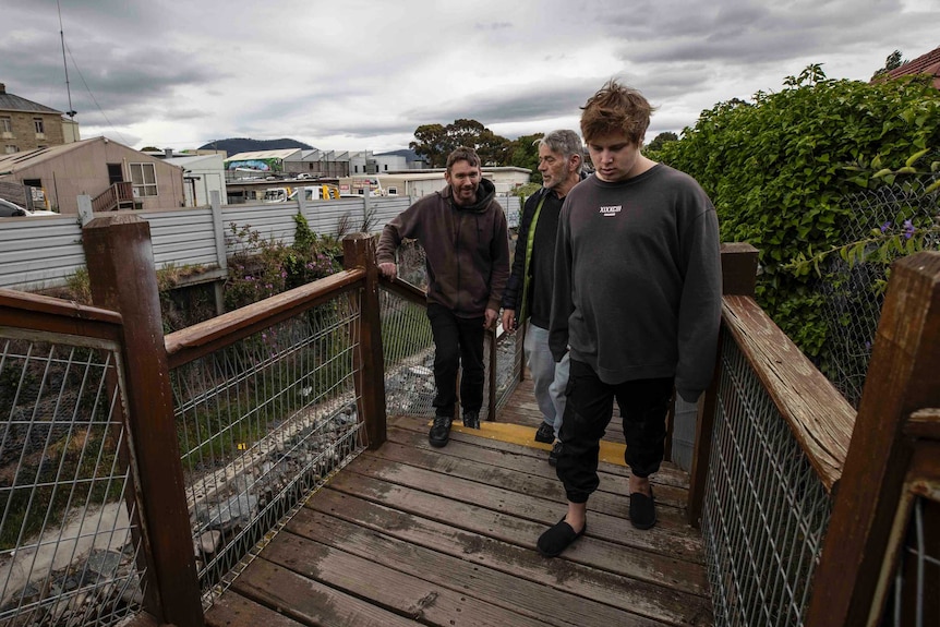 Three men walking up stairs