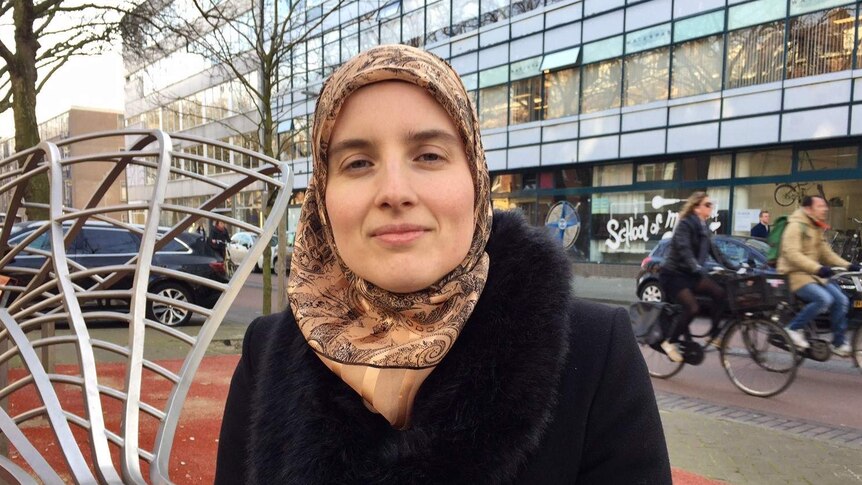 Marianne Vorthoren standing in front of cyclists on a Rotterdam street.