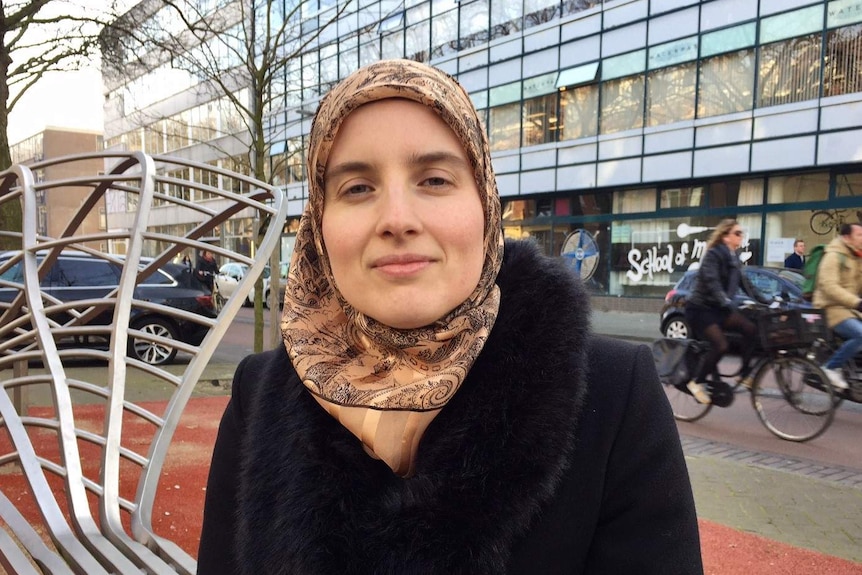 Marianne Vorthoren standing in front of cyclists on a Rotterdam street.