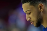 NBA player Ben Simmons is seen in profile, looking down.