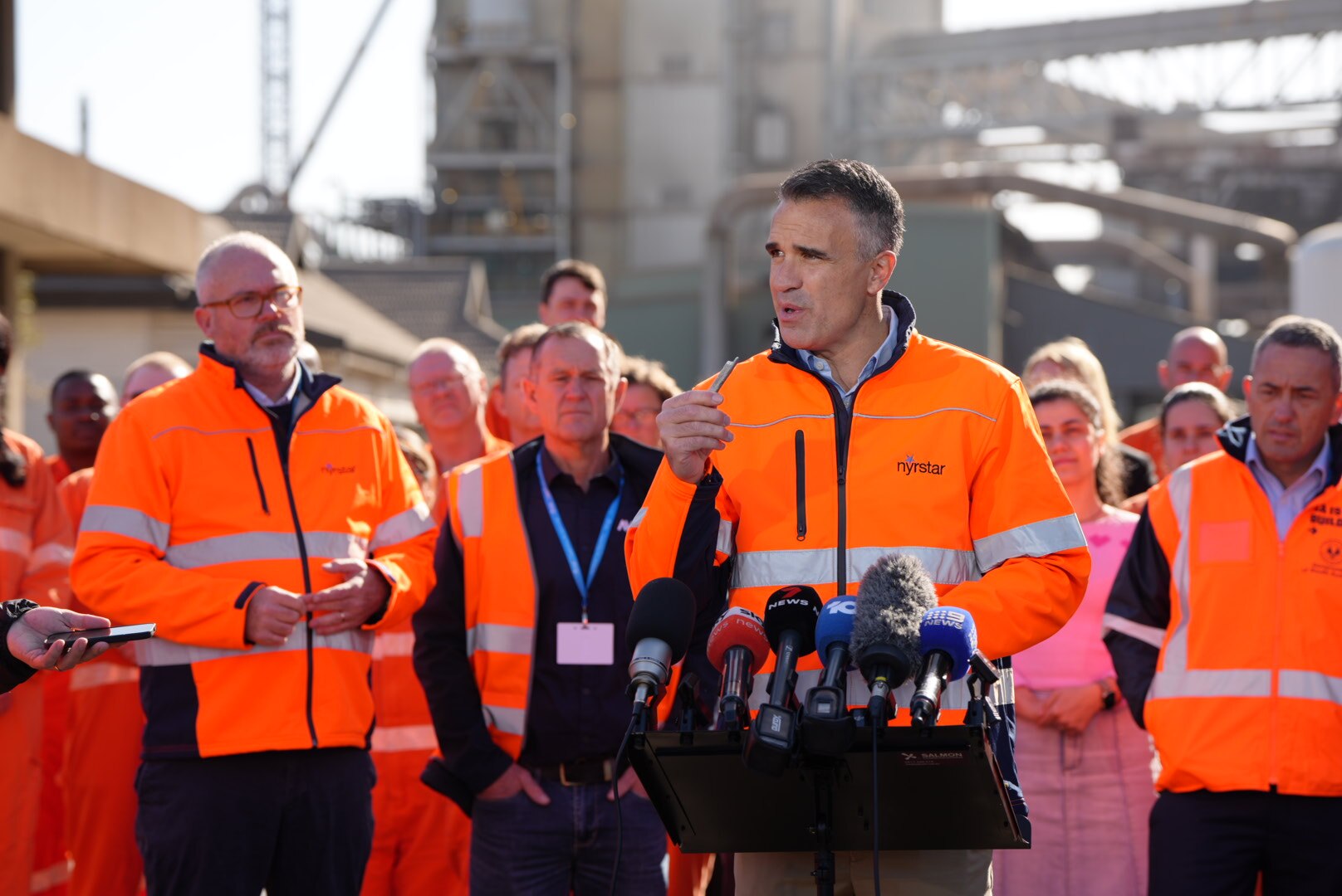 Peter Malinauskas holds up a piece of metal.