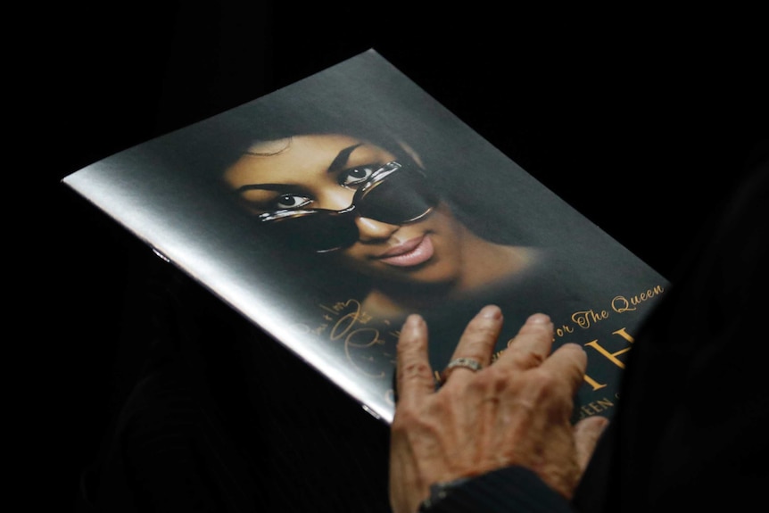 A person holds a program during the funeral service for Aretha Franklin