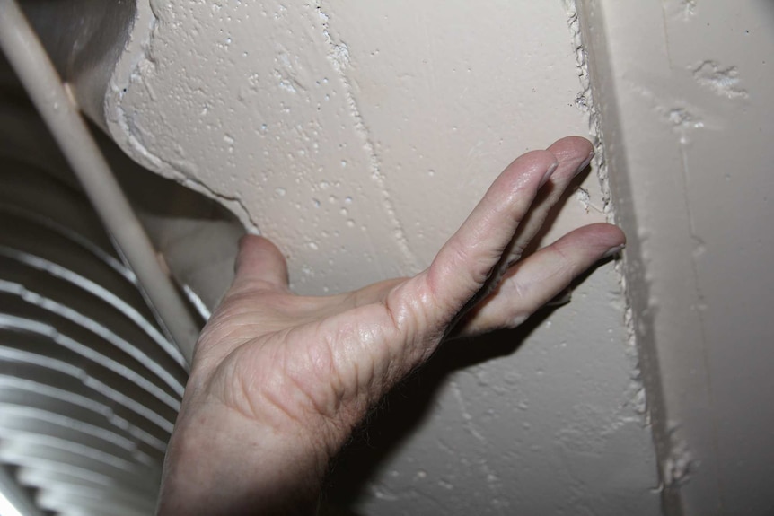 An outstretched hand shows the thickness of concrete from thumb to finger