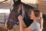 Grace Norley patting her horse Sydney