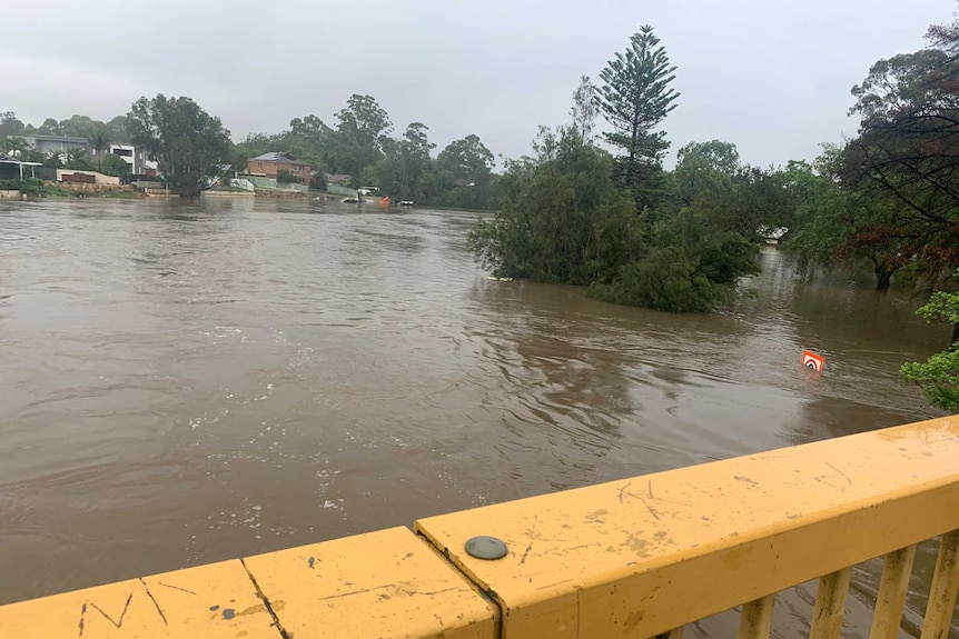 A photo taken from a bridge which shows the river spilling.