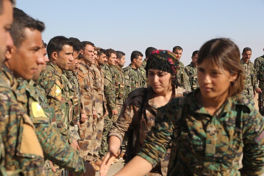 YPG and YPJ members great each other during a  graduation ceremony at a military training base