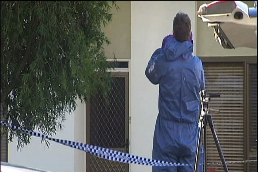 Forensic police officer in blue suit outside Launceston house where a man was found dead.