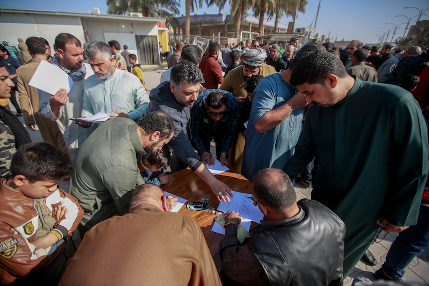 A group of men gather around a table to sign a pledge to stand against homosexuality or LGBTQ.