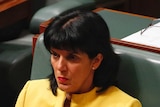 Liberal member for Chisholm Julia Banks sits in the house of reps, wearing a yellow blazer