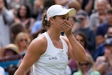Ash Barty puts a hand to her face as the crowd applauds her win at Wimbledon