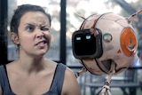 A young woman makes a funny face next to a robot