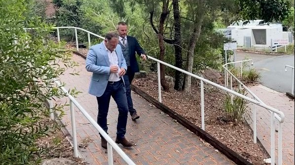 Two men in suits walk away from a court building.