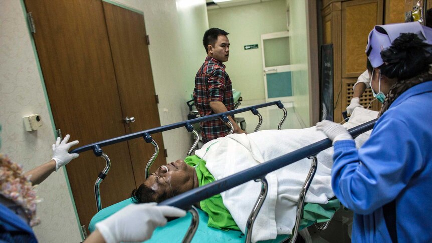 Red Shirt leader Kwanchai Praipana lies on stretcher