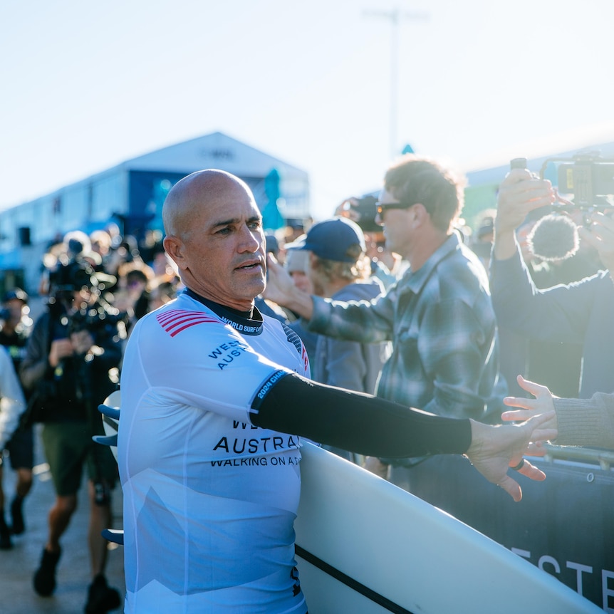 Surfer Kelly Slater high fives a fan as he walks through the crowd at the Margaret River Pro.