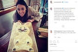 A smiling Jacinda Ardern pictured with a cake in the shape of a rabbit covered in coconut.