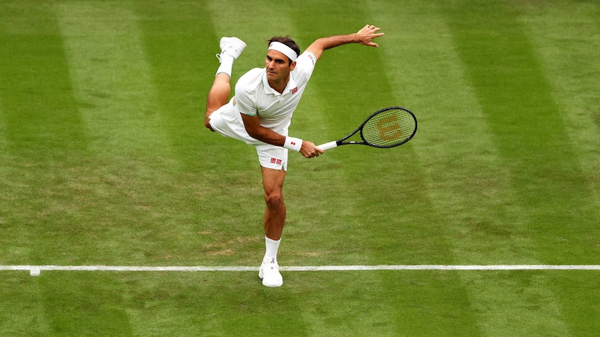 Roger Federer, dressed in tennis whites, plays a shot on the Wimbledon grass court. His pose is balletic.