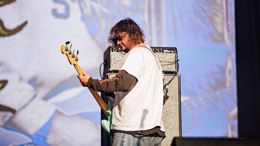 Toby Cregan of Skegss performs live in a white shirt and sunglasses at Splendour In The Grass 