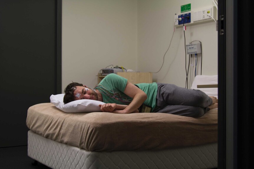 Joel Werner lies on a bed at the Woolcock Medical Research Institute during a sleep study, 2016