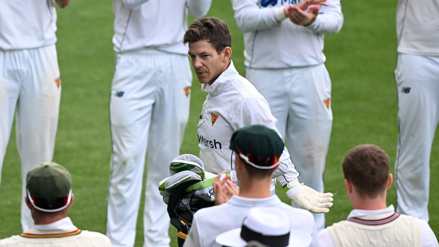 Tim Paine walks through a guard of honour in his whites after playing for Tasmania