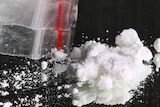 White power drug, sprinkled on reflective surface, with ziplock plastic bag.