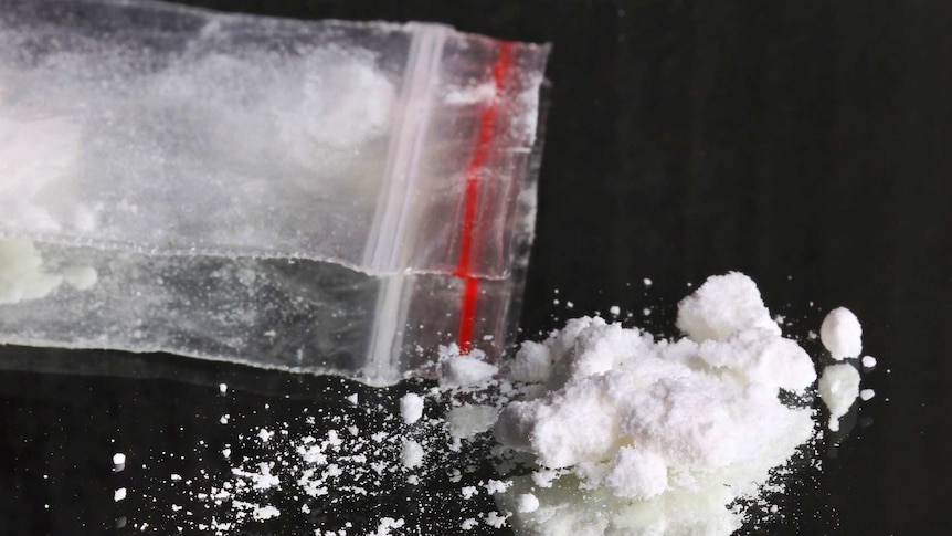 White power drug, sprinkled on reflective surface, with ziplock plastic bag.