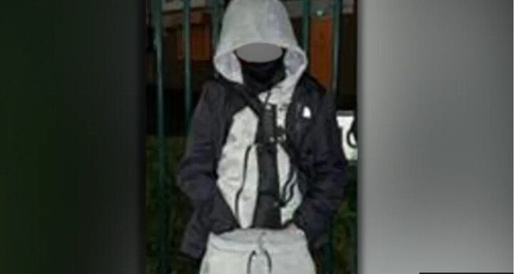 Boy wearing grey tracksuit has machete. 