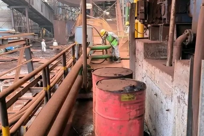 A worker wearing a hard hat at an industrial site.