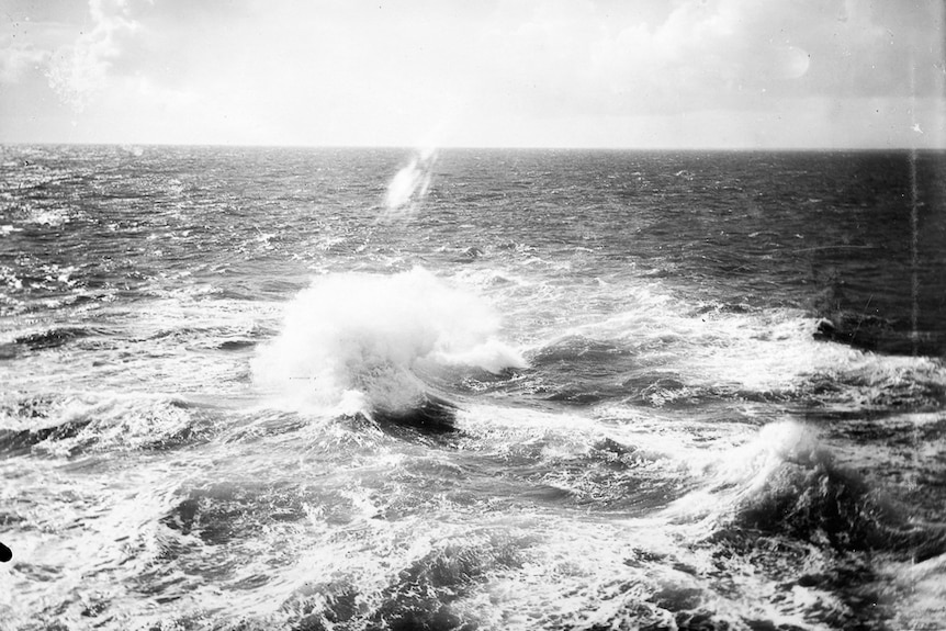 A black and white photograph of large waves crashing.