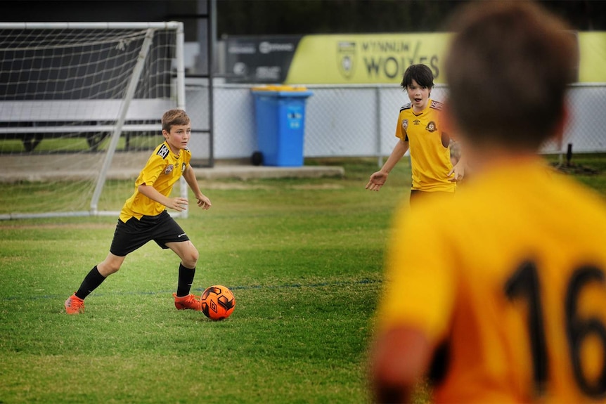 12-year-old in uniform with the soccer ball.