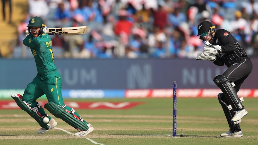 A New Zealand wicketkeeper flinches behind the stumps as a South African batsman square cuts the ball.