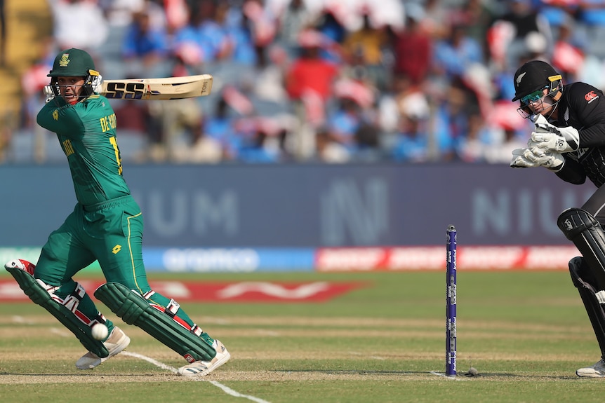 A New Zealand wicketkeeper flinches behind the stumps as a South African batsman square cuts the ball.