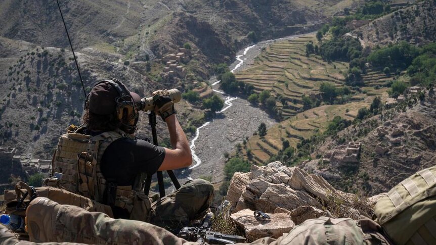 A US Air Force combat controller calls in airstrikes high above a valley in Afghanistan.