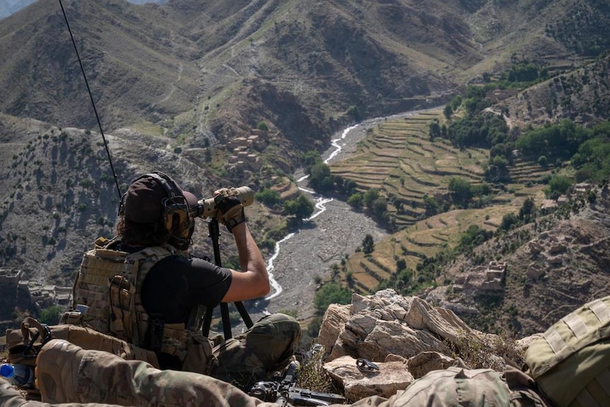 A US Air Force combat controller calls in airstrikes high above a valley in Afghanistan.