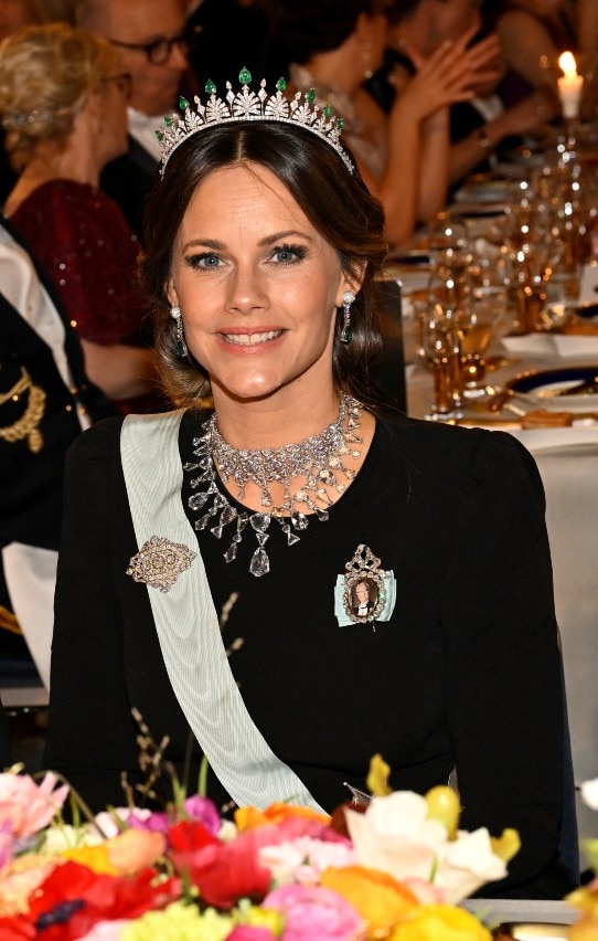 Una mujer vestida formalmente sonríe a la cámara.