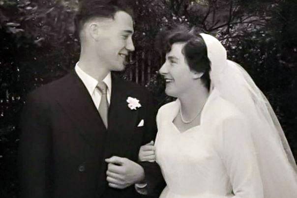 A black and white photo of a man and a woman staring lovingly at each other on their wedding day