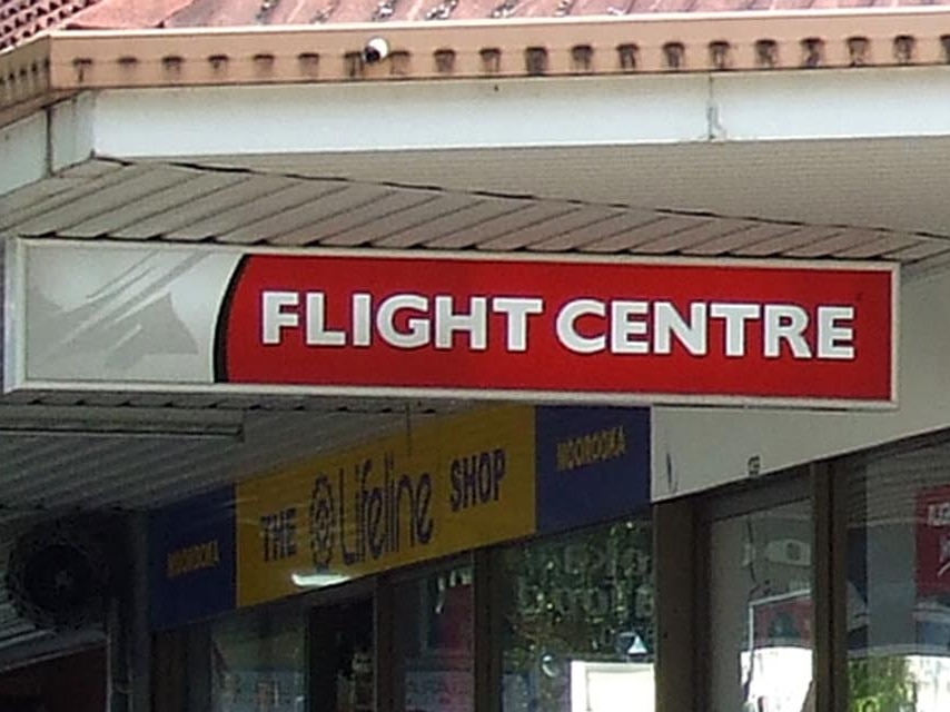 A Flight Centre sign outside some shops