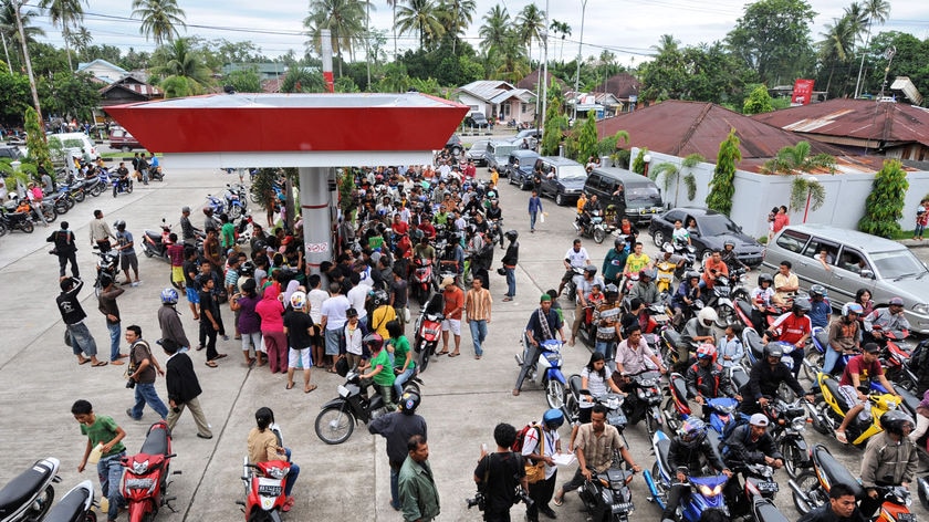 Indonesian motorists queue for petrol at a station in Padang