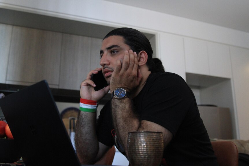 An Iranian appearance young man on the phone looking worried
