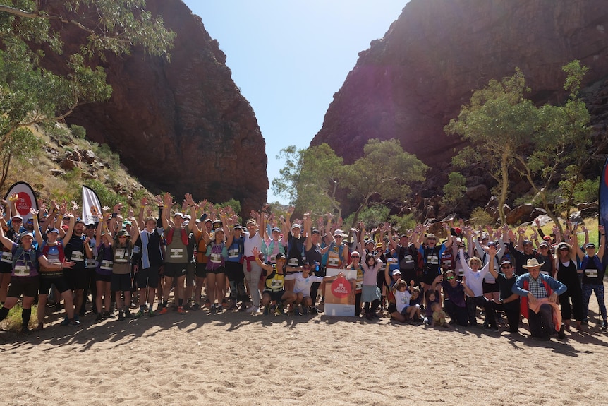 crowd of runners at simpsons gap in central australia, with their hands in the air