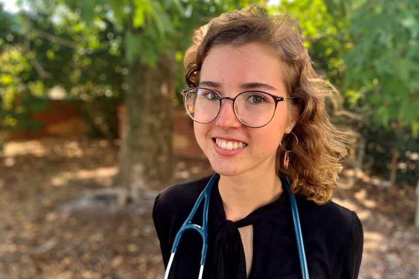 Woman wearing a stethoscope around her neck, smiling at camera.